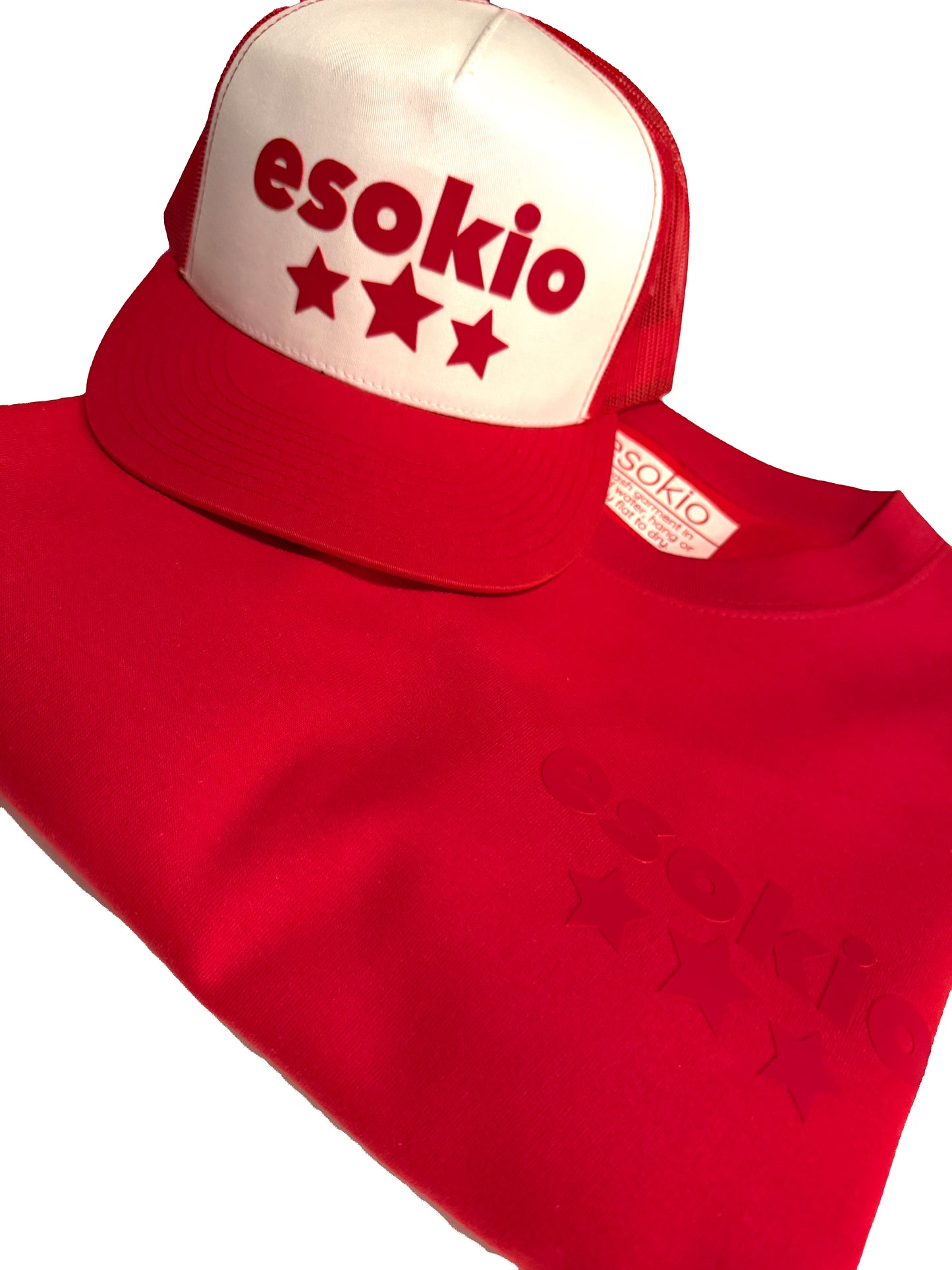 Red crewneck sweatshirt with 'esokio' branding and a matching cap on a white background